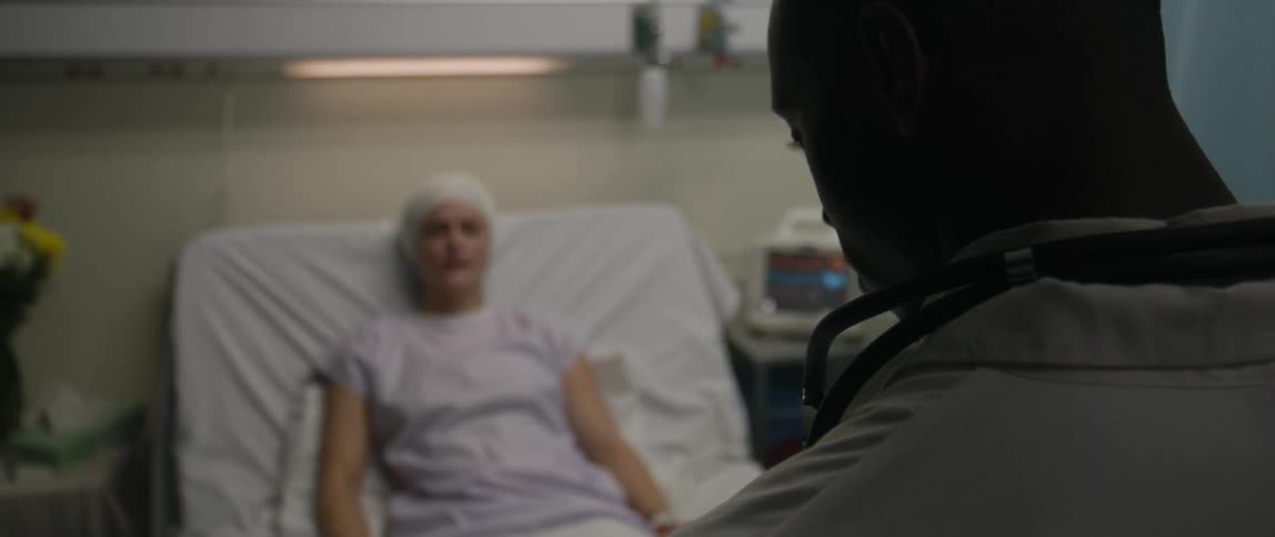 A doctor visits his patient in the hospital bed