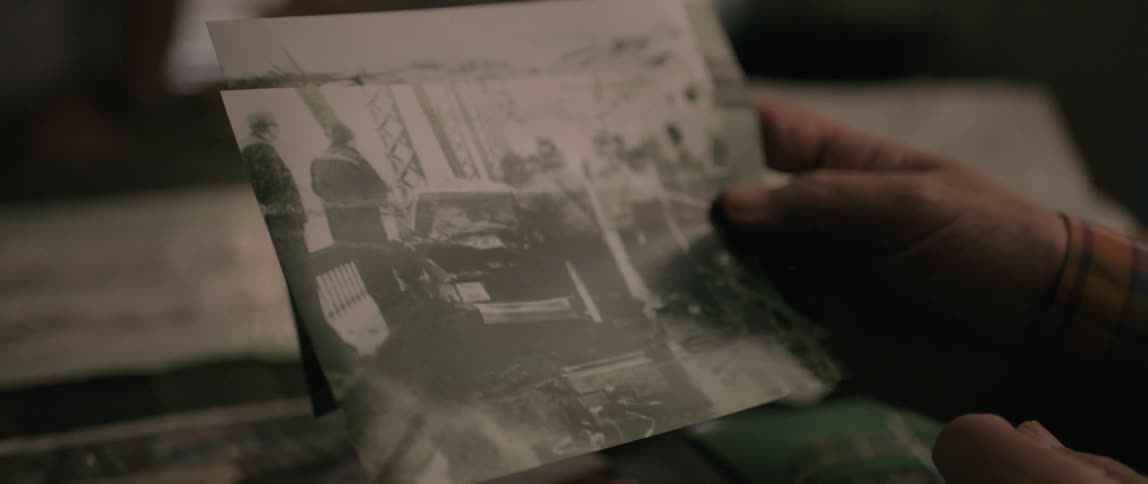 A man points at a picture he is holding