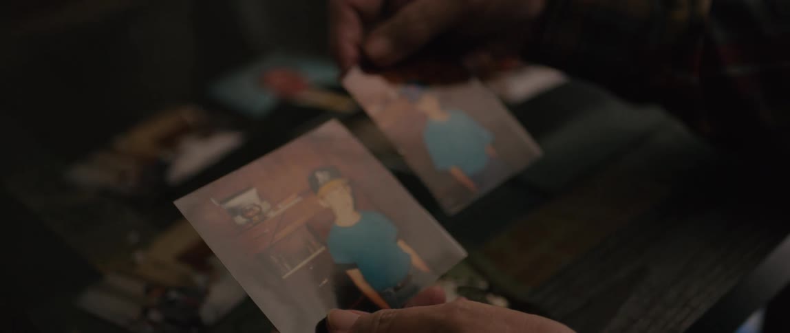 A man is holding two photographs