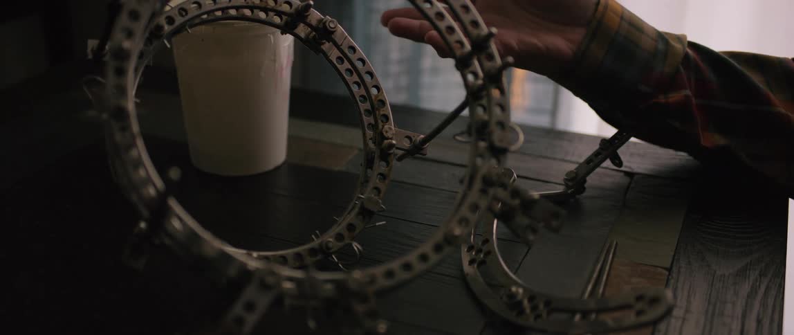 Hand next to a metal gauntlet on the table