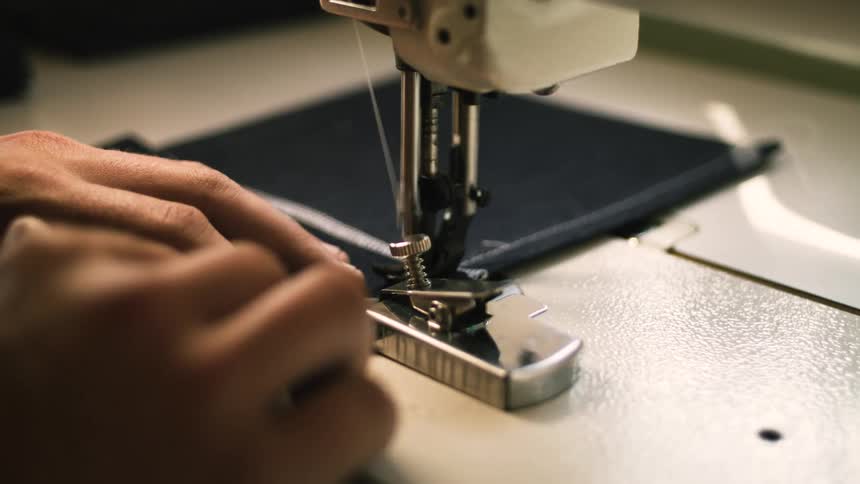 Pair of hands sewing a fabric