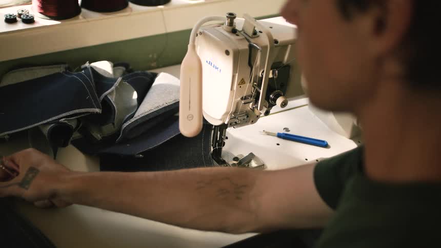 Man working with fabric next to a sewing machine