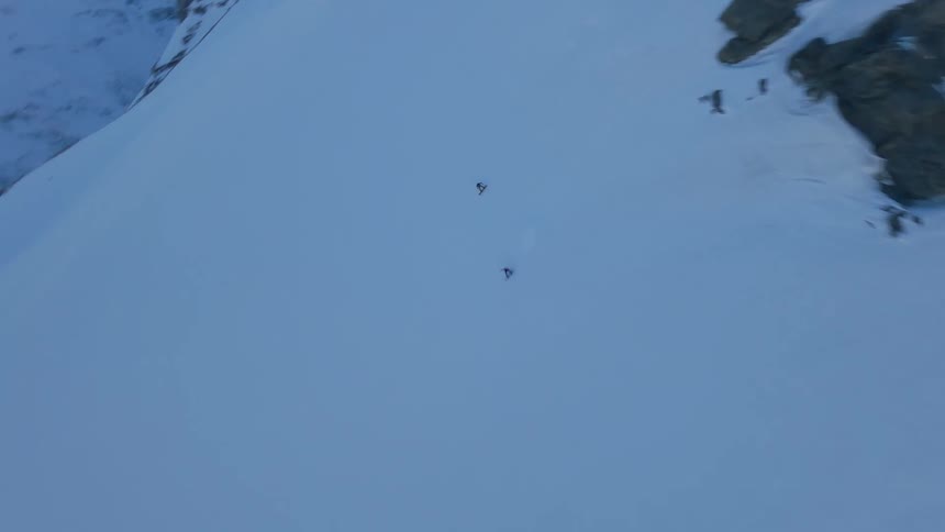 Two people snowboarding down the snow covered mountain at daytime