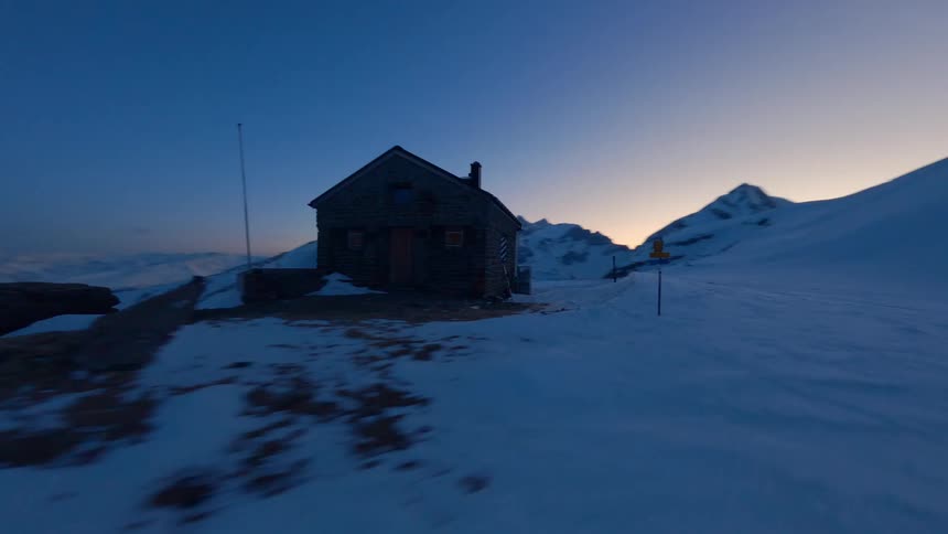 Aerial view of a wooden lodge in the middle of a snowy mountain