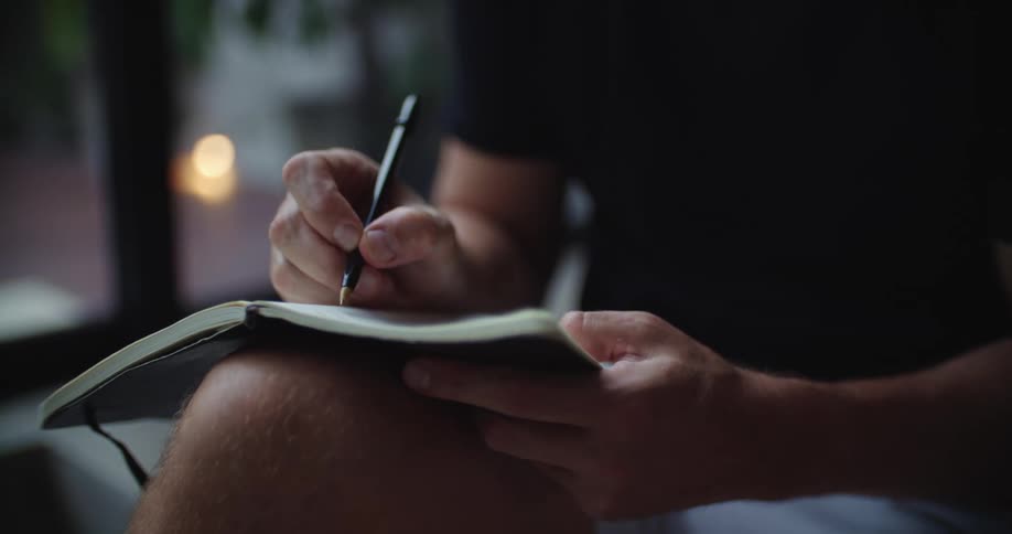 A man is writing in his notebook