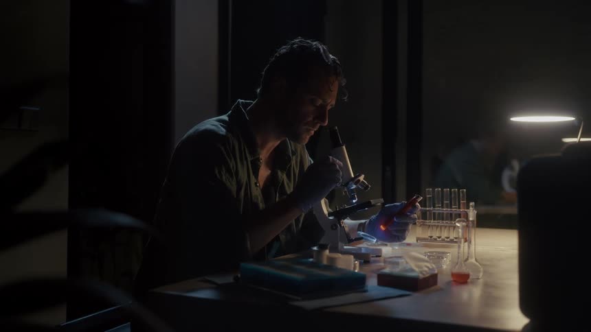 The scientist is using a microscope in the laboratory
