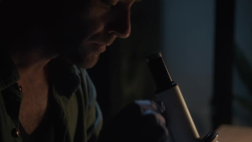 A man looks into a microscope