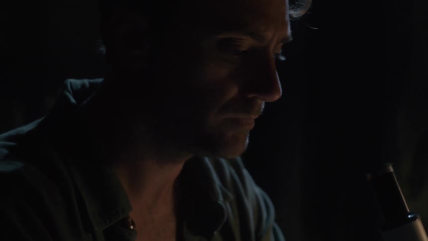 A man examines something through his microscope