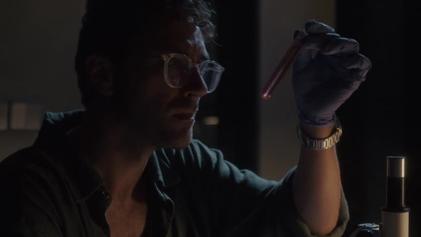 A scientist shakes a test tube