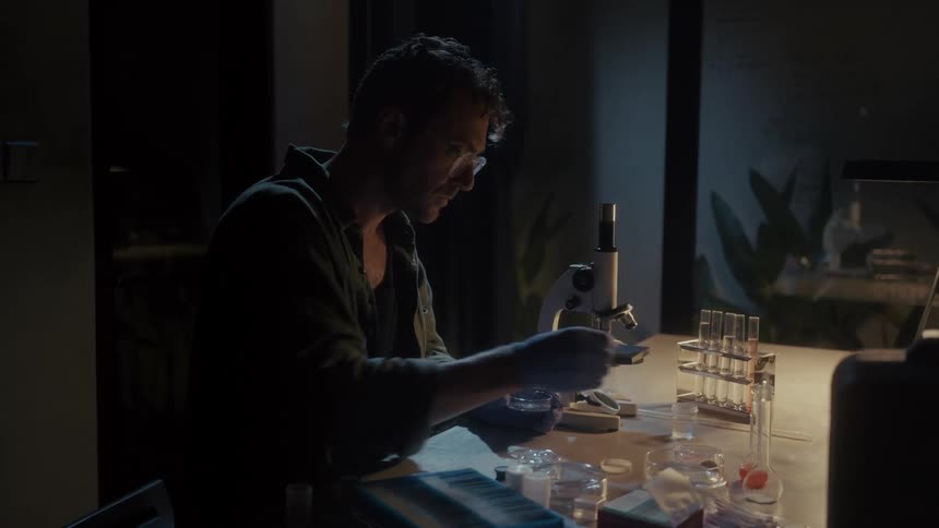 A man is using a microscope to observe some tissue samples