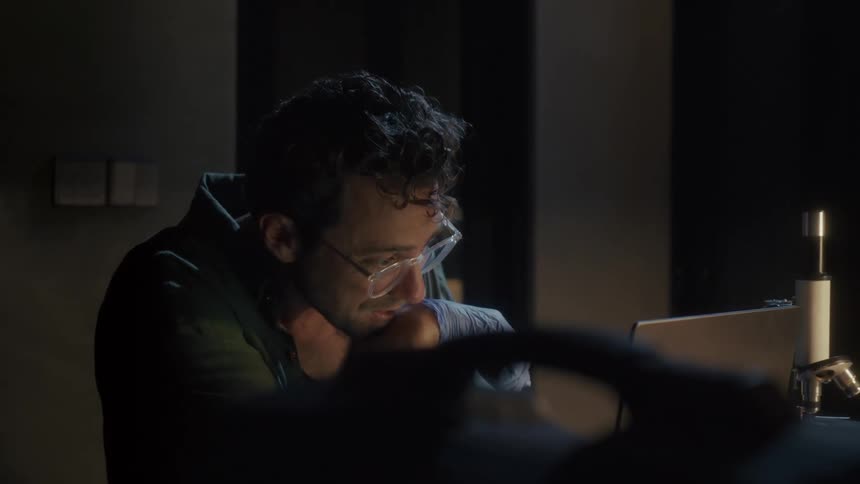 A scientist is using his laptop in the lab