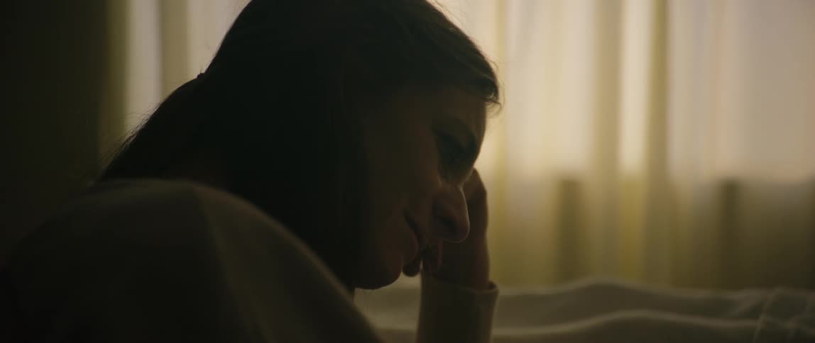 A woman looks sad in the dark room