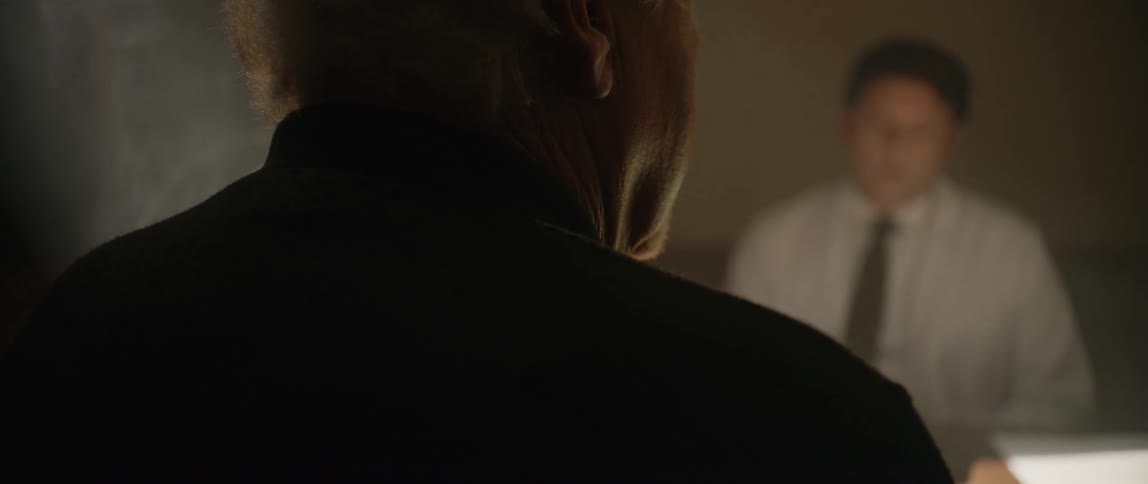 Two men are talking in the smoke filled room