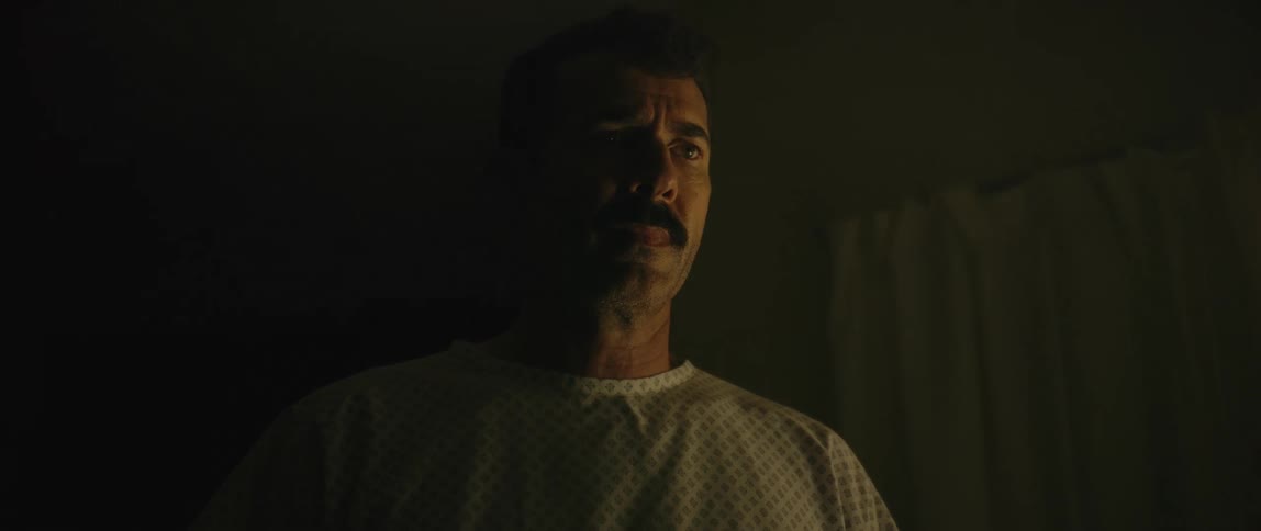 Man in a dark room with a scared expression
