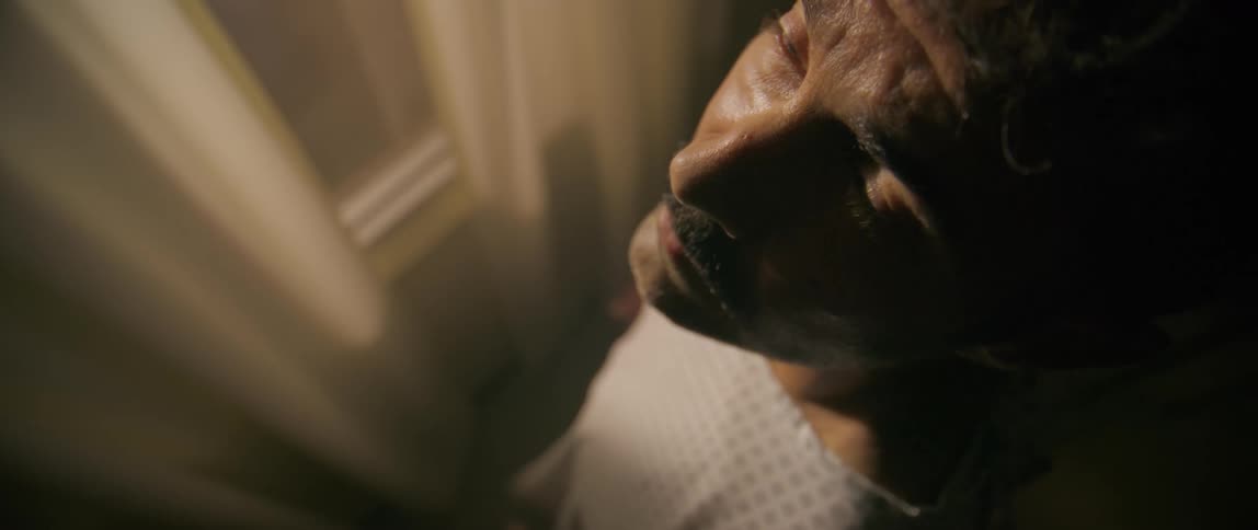 A man looks up at the ceiling by the window