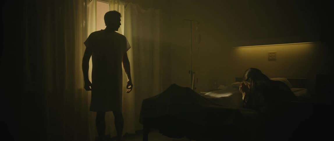A hospital patient walks form the window towards a visitor