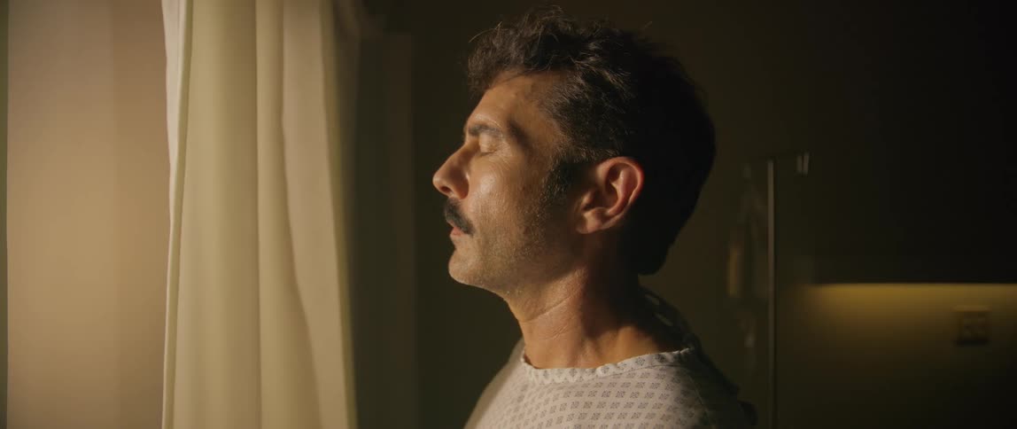 A man is taking in sunshine from the window in the hospital