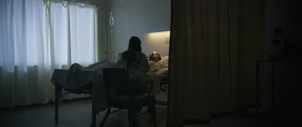 A woman is nervous as a man cries out in pain in the hospital bed