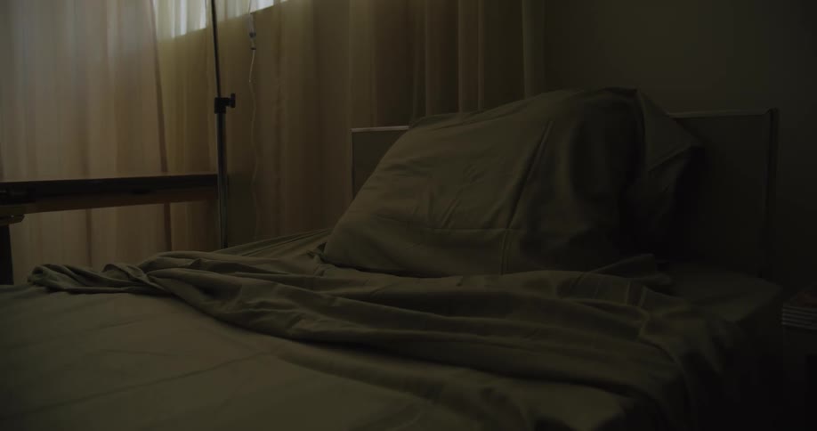 The dark hospital room is empty
