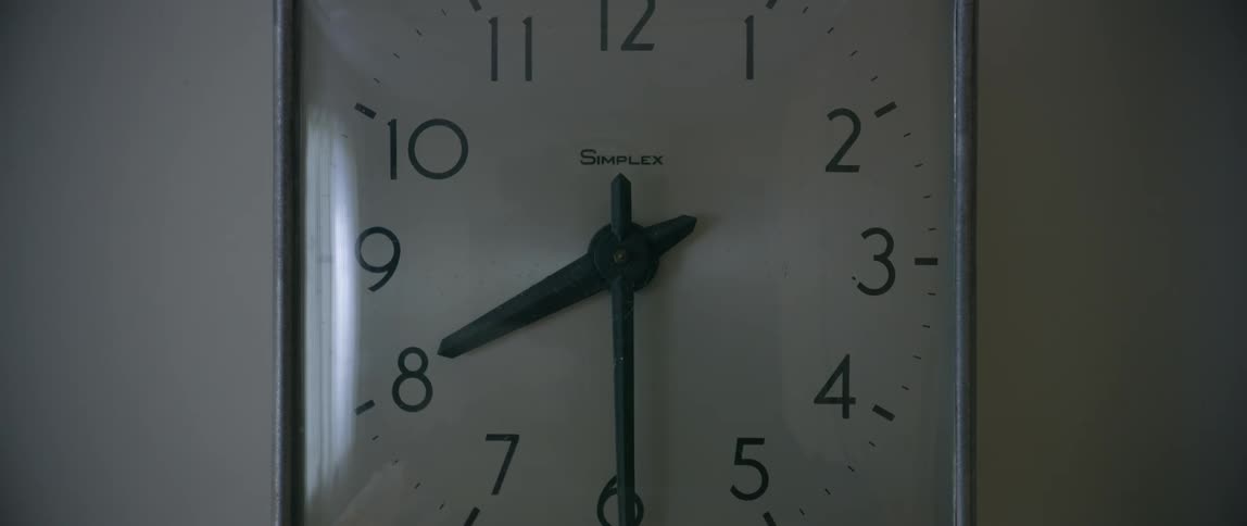 The analog clock is hanging on the wall