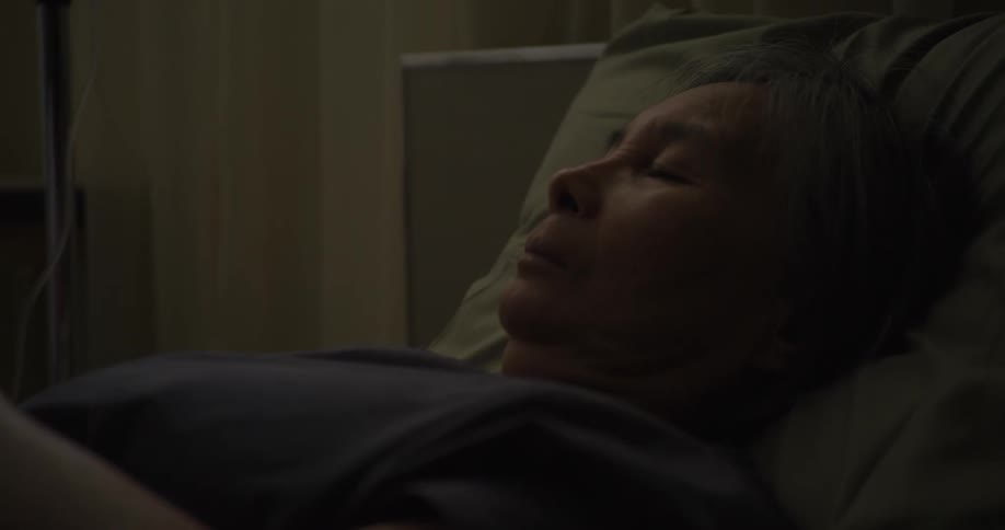 Elderly woman sleeps on a hospital bed