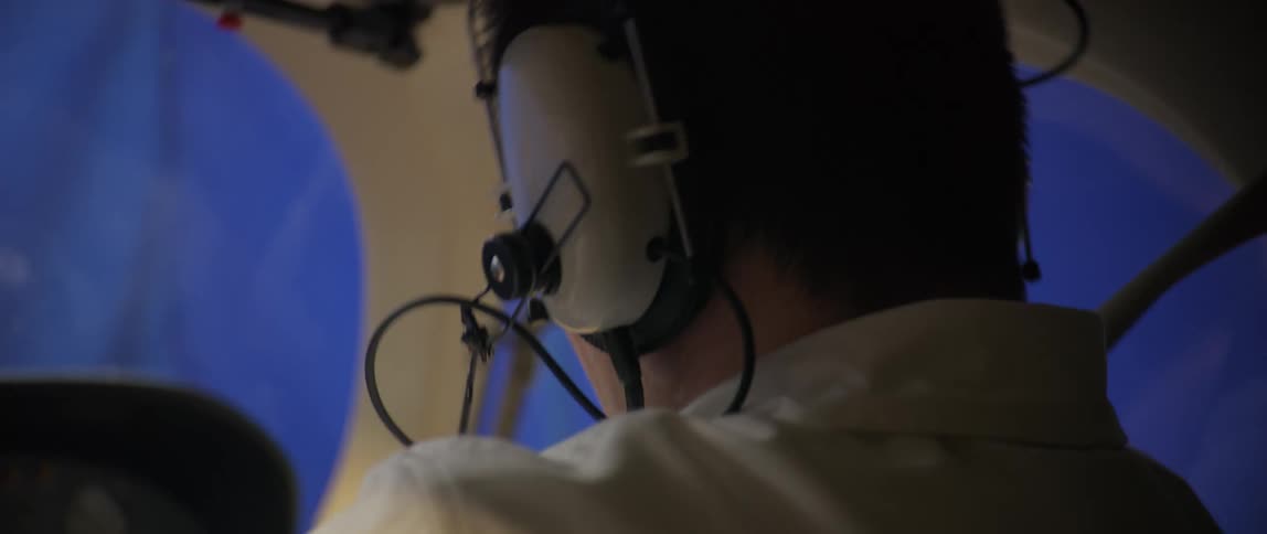 Pilot with headphones in a shaking airplane cabin