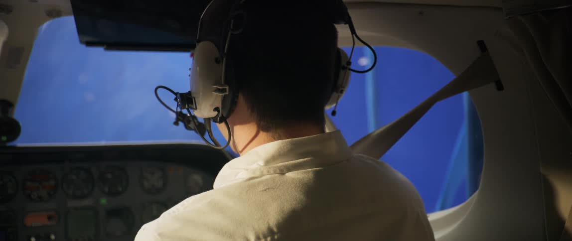 Pilot with headset inside an airplane cabin