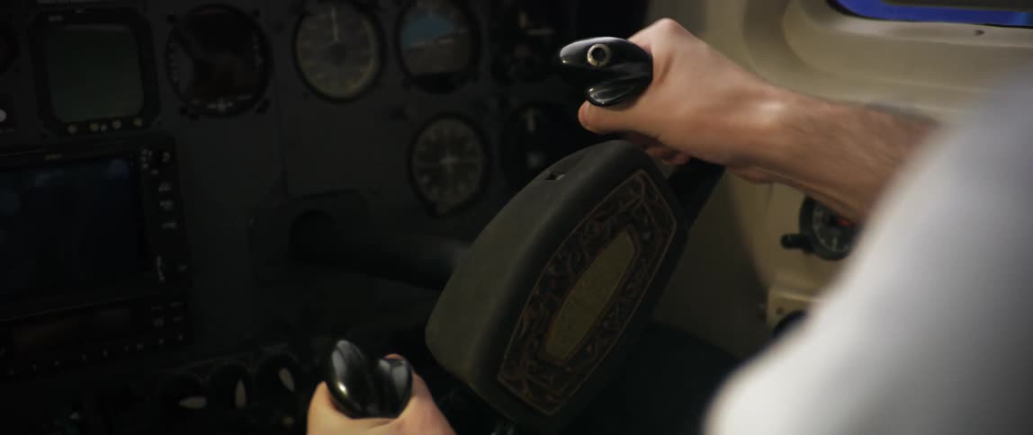 Male pilot uses the yoke to fly an airplane while in its cockpit