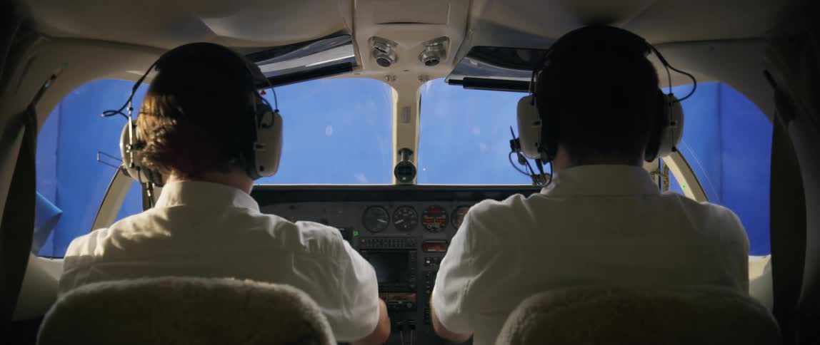 Two pilots steer an airplane