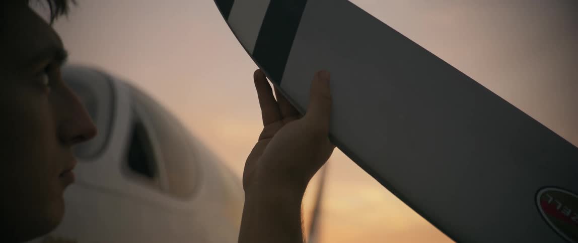 A man traces his hand along the propeller