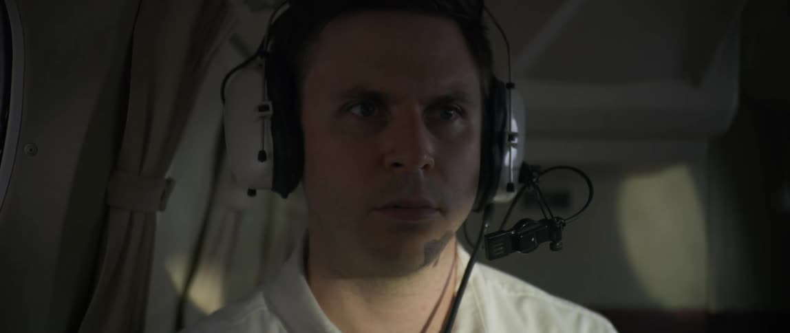 The pilot makes a hand gesture while flying a plane