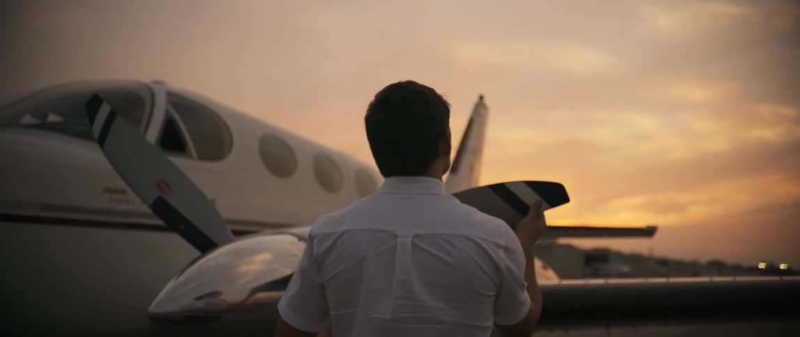 A pilot is checking over the plane