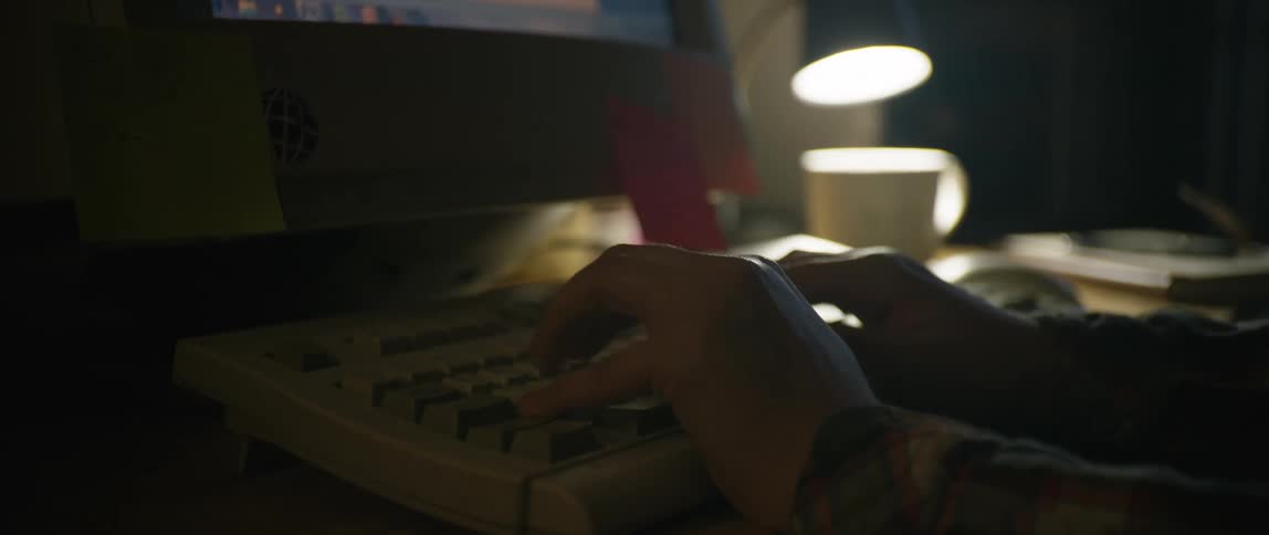 A person sits at a desk and types on a keyboard