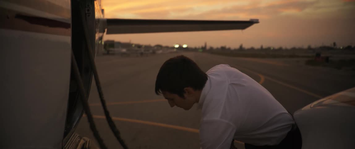 A pilot opens and closes the doors to compartments on the exterior of a plane