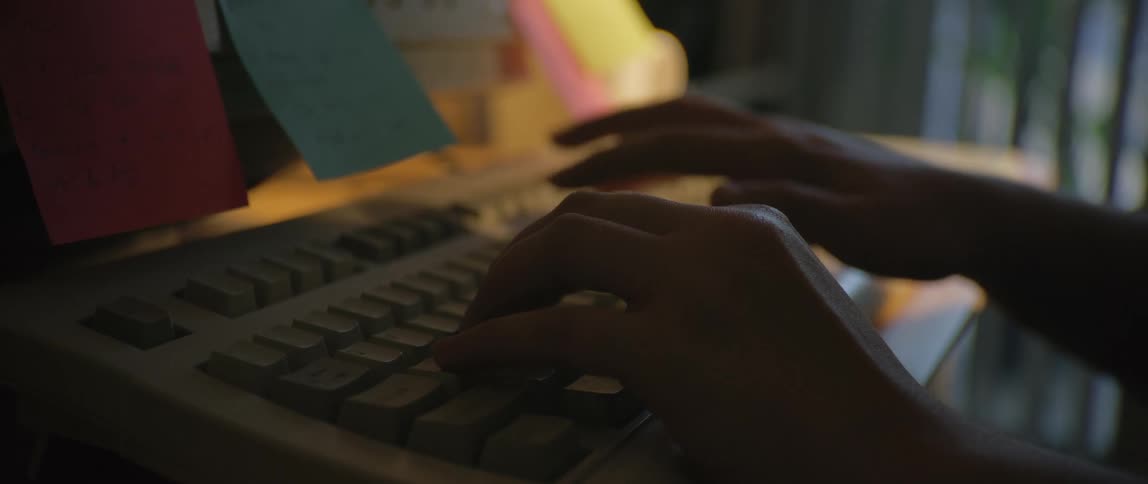 A person types on a keyboard with both hands