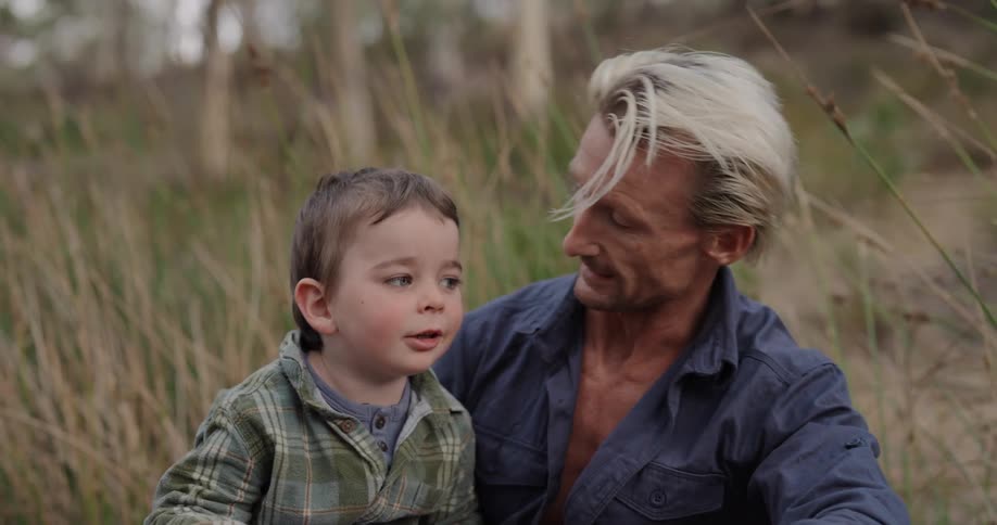 A father talks with his son and points