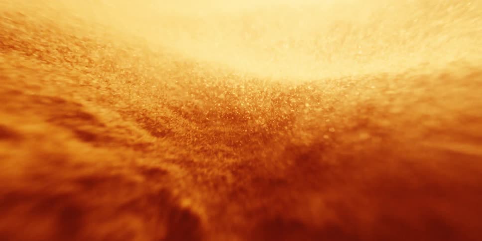 Abstract fiery sand becoming airborne during a storm in the desert at sunset