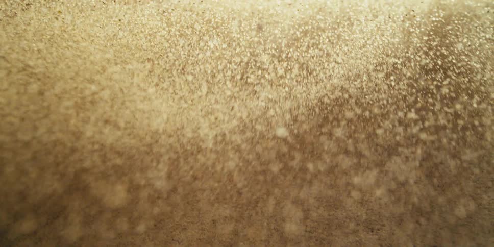 Macro Sand Particles Lifting Into a Cloud Before Settling Back