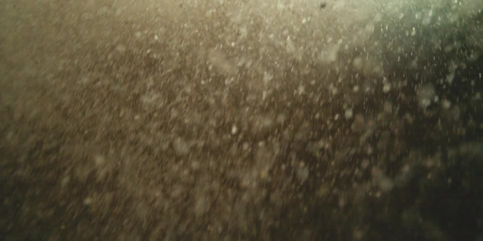 A cascading chaotic dive into energetic water with individual drops of water and bubbles scattering in all directions