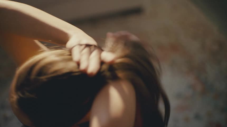 Woman putting her hair in a ponytail with hair band