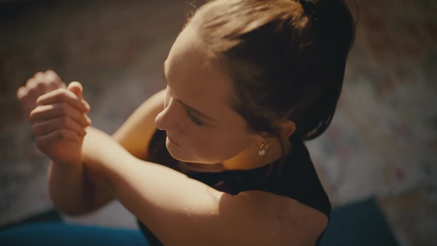 A woman puts her phone away and starts doing yoga