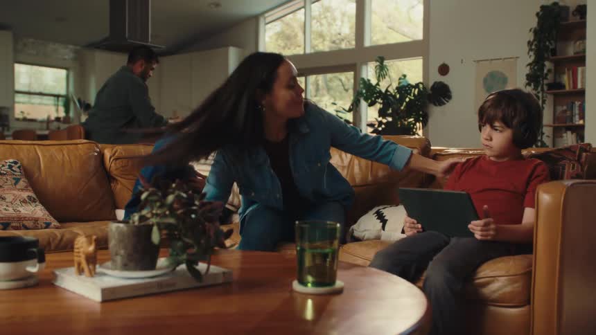 Mother standing up from the couch encourages her children to put down their mobile devices and follow her