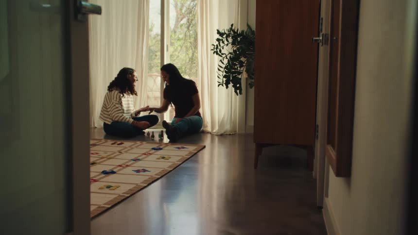 Two women talking while sitting on the floor of a room