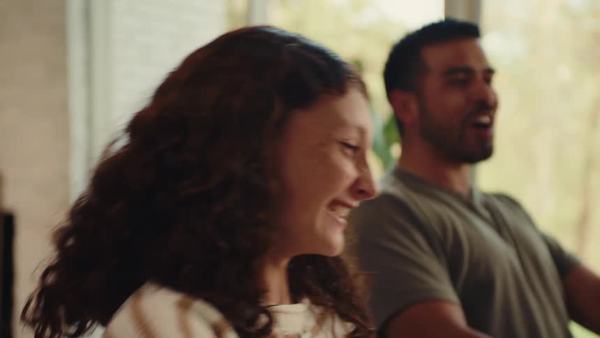 Three happy people while playing a board game while throwing dice on a table