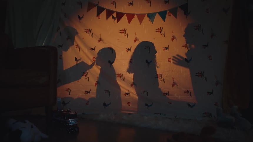A families shadow can be seen behind the blanket as they interact