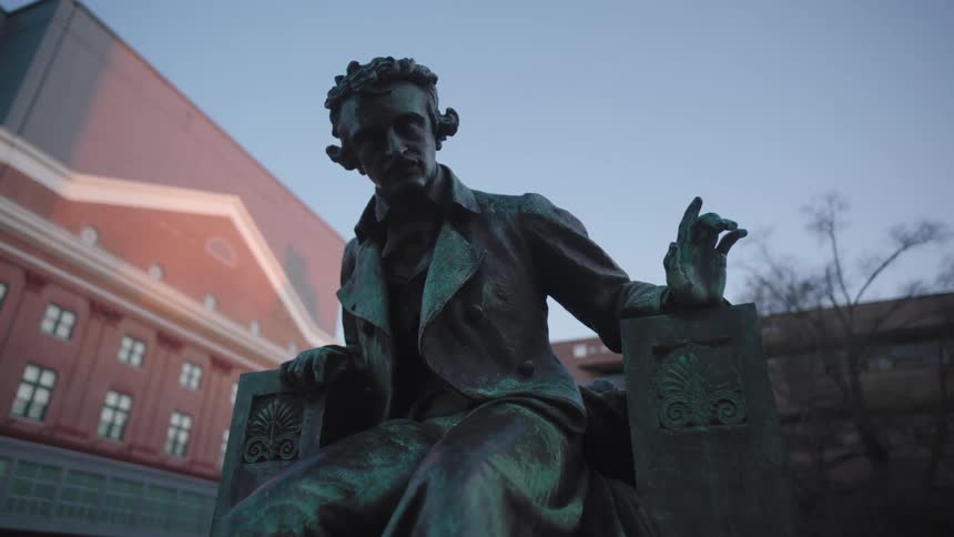 A statue of a man is in front of the public buildings