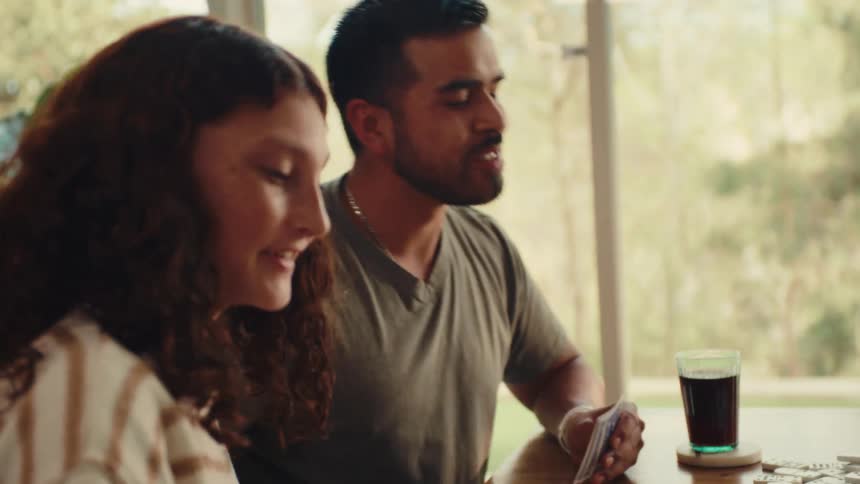 Man and woman sitting at a table having fun playing cards