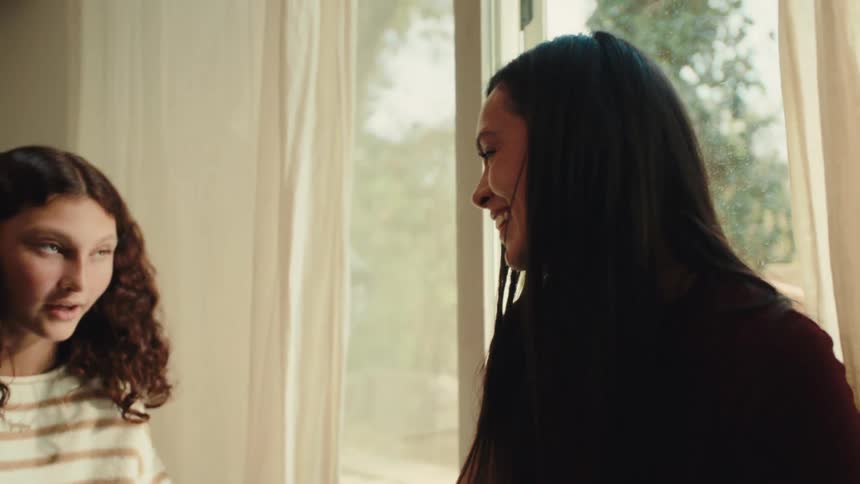 Friends laugh and talk while a teenager is applying nail polish