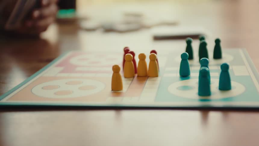 Friends move pieces on the board game