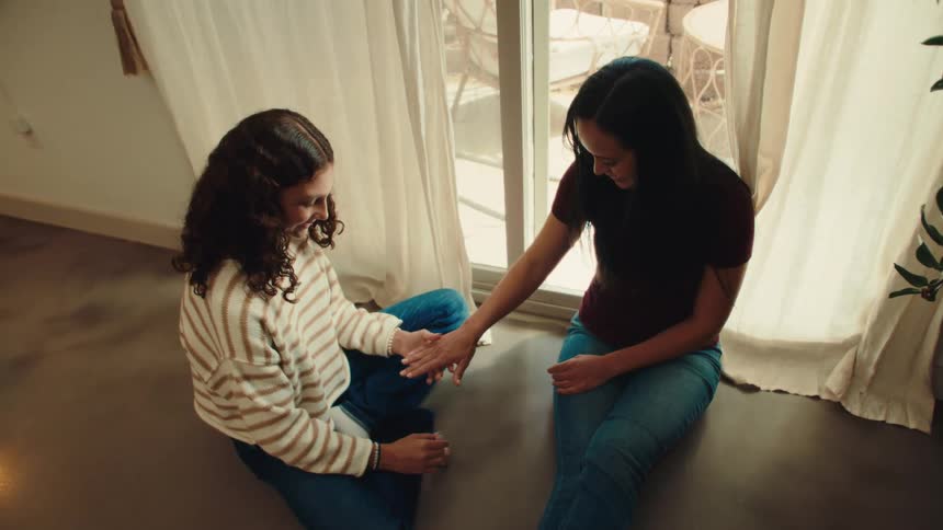 A girl is putting nail polish on a woman